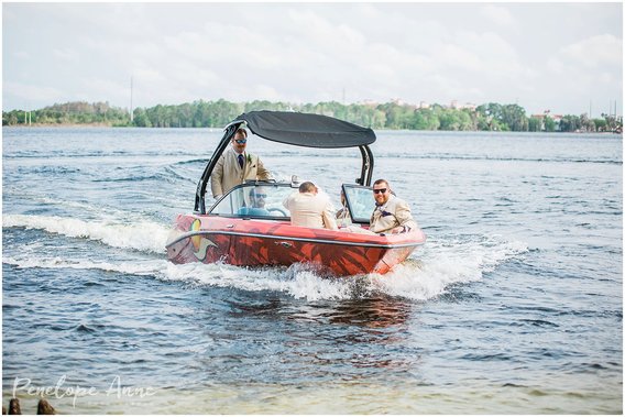 Groomsmen arrive wedding ceremony on speed boat at paradise cove